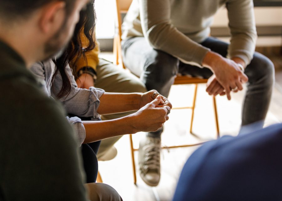 Close up shot of unrecognizable people anxiously fidgeting their hands while sharing stories during a group therapy session.